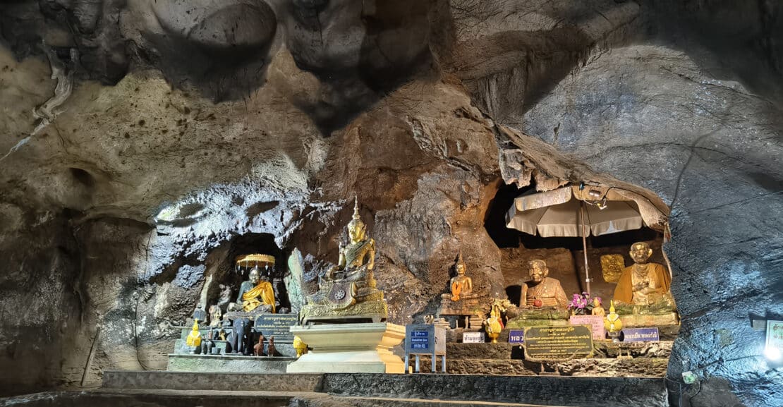 Buddha statues inside Chiang Dao Cave illuminated by soft lights